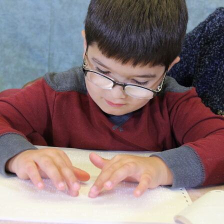 Boy reading braille